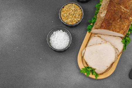 High-protein roasted pork loin served with flavor spices, styled for food photography. Suitable for keto and paleo diets, black stone background, top viewの写真素材