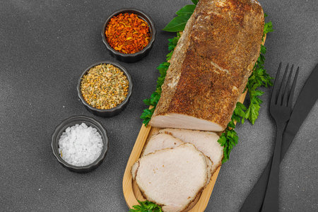 High-protein roasted pork loin served with flavor spices, styled for food photography. Suitable for keto and paleo diets, black stone background, top viewの写真素材