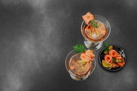 Stylish salmon martini cocktail served with smoked salmon, olive, lemon, and dill. High-end mixology trend. Perfect for bar menus, lifestyle or gourmet drink features, top viewの写真素材