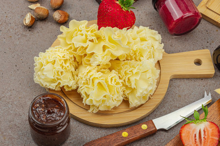 Cheese assortment on rustic background with nuts, strawberries and jam. Includes Tête de Moine, Roquefort, Saint Agur and Gouda on wooden boards, close upの写真素材