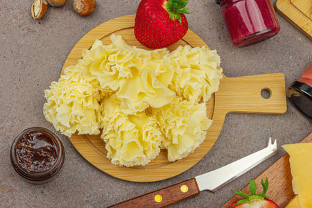 Cheese assortment on rustic background with nuts, strawberries and jam. Includes TÊªte de Moine, Roquefort, Gouda on wooden boards, top viewの写真素材