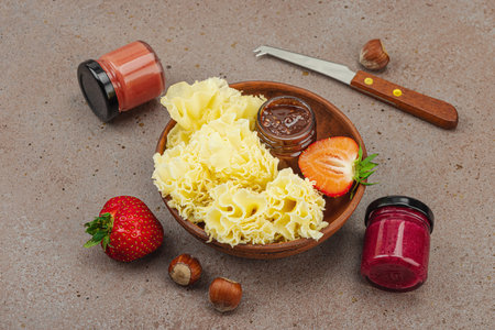 Cheese assortment on rustic background with nuts, strawberries and jam.の写真素材