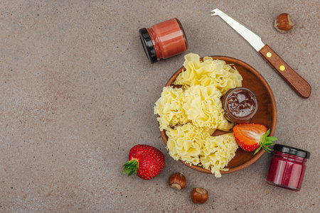 Cheese assortment on rustic background with nuts, strawberries and jam. Includes Tête de Moine, Roquefort, Gouda on wooden boards, top viewの写真素材
