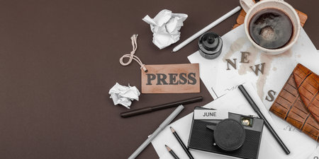 Creative flat lay with vintage camera, press tag, ink bottle, spilled coffee, and messy papers. A symbolic tribute to journalism, OSINT, and the pursuit of truth, banner formatの写真素材