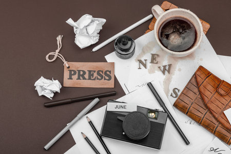 Creative flat lay with vintage camera, press tag, ink bottle, spilled coffee, and messy papers. A symbolic tribute to journalism, OSINT, and the pursuit of truth, top viewの写真素材