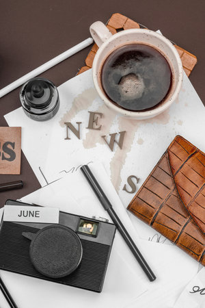 Creative flat lay with vintage camera, press tag, ink bottle, spilled coffee, and messy papers. A symbolic tribute to journalism, OSINT, and the pursuit of truth, top viewの写真素材