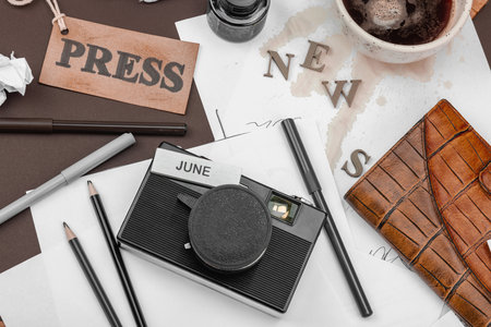 Creative flat lay with vintage camera, press tag, ink bottle, spilled coffee, and messy papers. A symbolic tribute to journalism, OSINT, and the pursuit of truth, top viewの写真素材