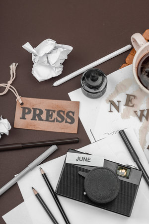 Creative flat lay with vintage camera, press tag, ink bottle, spilled coffee, and messy papers. A symbolic tribute to journalism, OSINT, and the pursuit of truth, top viewの写真素材