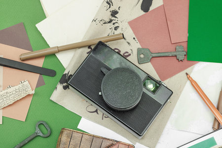 Flat lay with vintage camera, cassette, notebook, key and research tools on green background, symbolizing journalism, OSINT, and the pursuit of truth, top viewの写真素材