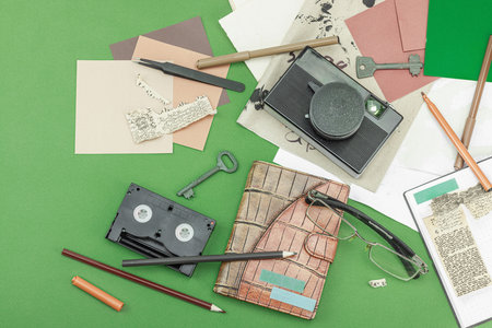 Flat lay with vintage camera, cassette, notebook, key and research tools on green background, symbolizing journalism, OSINT, and the pursuit of truth, top viewの写真素材