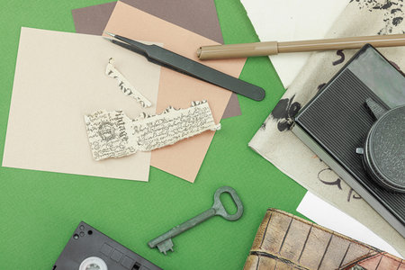 Flat lay with vintage camera, cassette, notebook, key and research tools on green background, symbolizing journalism, OSINT, and the pursuit of truth, top viewの写真素材