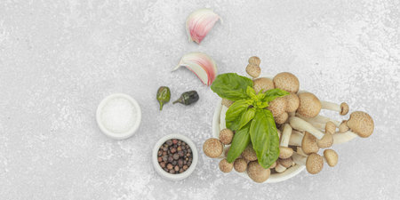 Fresh assorted shimeji mushrooms with olive oil, basil, garlic, salt, and pepper on rustic kitchen...