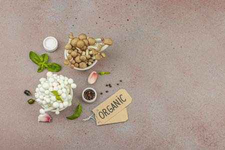Fresh assorted shimeji mushrooms with olive oil, basil, garlic, salt, and pepper on rustic kitchen background. Vegan ingredient for healthy eating, food concept, top viewの写真素材