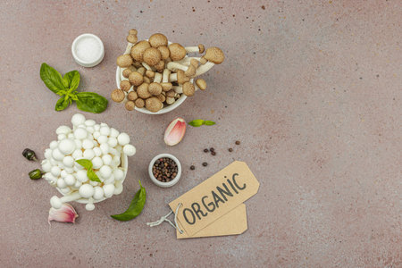 Fresh assorted shimeji mushrooms with olive oil, basil, garlic, salt, and pepper on rustic kitchen background. Vegan ingredient for healthy eating, food concept, top viewの写真素材