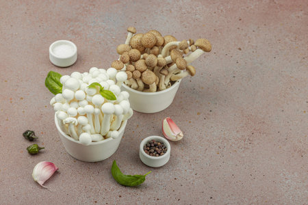 Fresh assorted shimeji mushrooms with olive oil, basil, garlic, salt, and pepper on rustic kitchen background. Vegan ingredient for healthy eating, food concept, copy spaceの写真素材