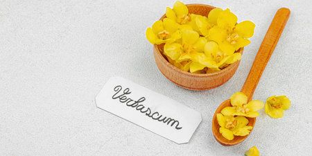 Fresh Verbascum flowers in a small wooden bowl with name tag. Alternative medicine, traditional...