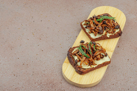 Healthy plant-based open sandwiches with sautéed Shimeji mushrooms. Protein rich vegan meal is...