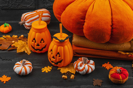 Halloween decoration with handmade fabric pumpkins, soft pillows, and pumpkin-shaped drink cups....