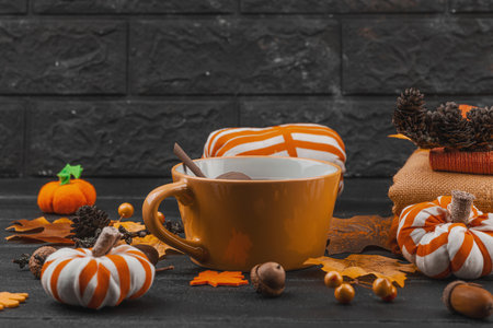 Cozy autumn still life with a cup of tea, handmade fabric pumpkins, acorns, pine cones, fall leaves, and textiles for crafts, symbolizing slow living and seasonal comfort, copy spaceの写真素材