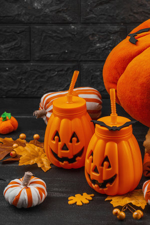 Halloween decoration with handmade fabric pumpkins, soft pillows, and pumpkin-shaped drink cups. Cozy seasonal setup symbolizing fall traditions and festive crafts, copy spaceの写真素材