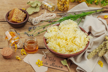 Rustic still life with cheese, honey, and dried herbs on a wooden table. Warm light and vintage atmosphere in apothecary style, flat lay, close upの写真素材