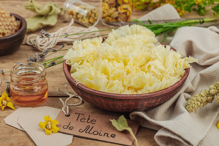 Rustic still life with cheese, honey, and dried herbs on a wooden table. Warm light and vintage atmosphere in apothecary style, flat lay, close upの写真素材
