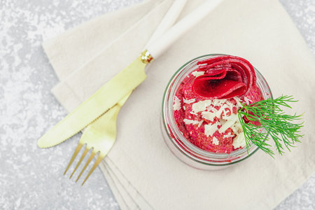 Vegan beet pasta salad in a glass jar, garnished with dill and red bell pepper. Healthy, vibrant,...