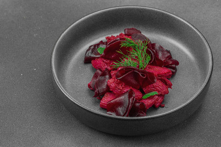 Vegan beetroot pasta with fresh dill and mint served in a trendy dark ceramic bowl. Healthy, plant-based and gut-friendly food, rustic style, black stone concrete background, close upの写真素材
