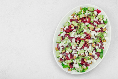 Fermented beetroot salad with cucumber, dill, pumpkin seeds, and feta cheese. A healthy winter meal, probiotic food, clean eating and a balanced diet. Light natural background, top viewの写真素材