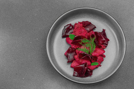 Vegan beetroot pasta with fresh dill and mint served in a trendy dark ceramic bowl. Healthy, plant-based food, rustic style, black stone concrete background, top viewの写真素材