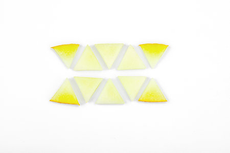 Geometric pattern of fresh pieces cut into squares, circles, and triangles. Abstract food design on a white background, top viewの写真素材