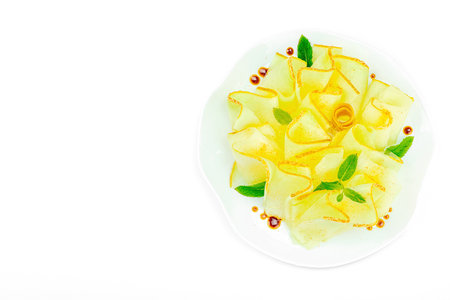 Thinly sliced melon carpaccio appetizer with fresh mint and balsamic sauce drops on a white plate. Gourmet isolated food design for healthy dining, top viewの写真素材