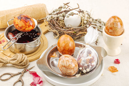 Still life with marble-patterned Easter eggs in a decorative birds nest. Natural dyes from onion...