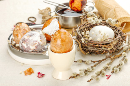 Still life with marble-patterned Easter eggs in a decorative birds nest. Natural dyes from onion...