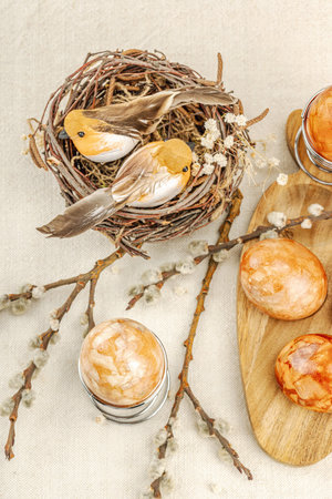 Easter eggs dyed with natural onion skins in a rustic setting with pussy willow branches, craft...