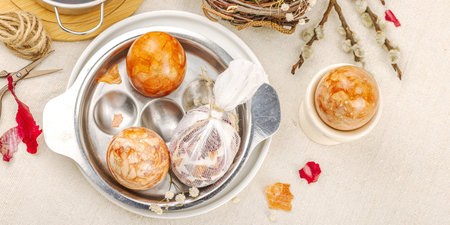 Still life with marble-patterned Easter eggs in a decorative birds nest. Natural dyes from onion...