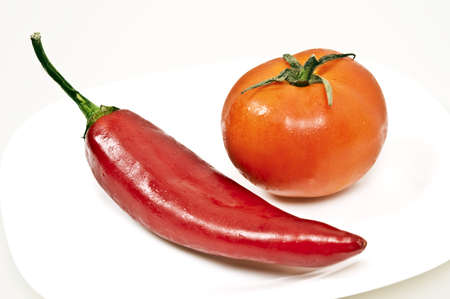 Isolated red pepper and tomato on white backgroundの写真素材