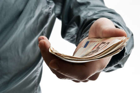 Young business man offering bunch of euro banknotesの写真素材