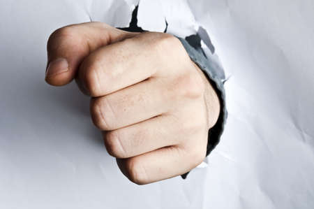 Male fist broke white paperの写真素材