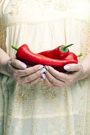 Housewife holding bunch of peppersの写真素材