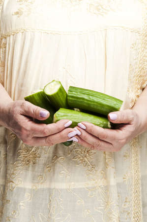 Housewife holding bunch of cucumbersの写真素材