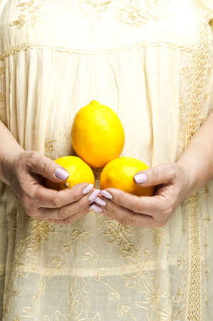 Housewife holding bunch of lemonsの写真素材