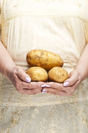 Housewife holding bunch of potatoesの写真素材