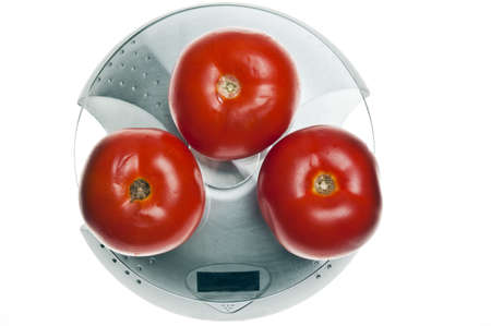 Tomatoes isolated on food scaleの写真素材