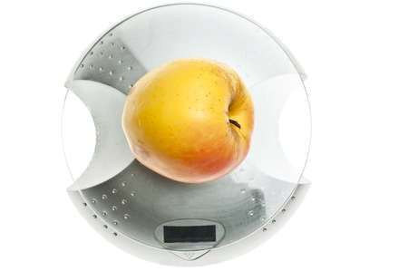 Yellow apple isolated on food scaleの写真素材