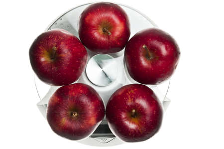 Red apples isolated on food scaleの写真素材