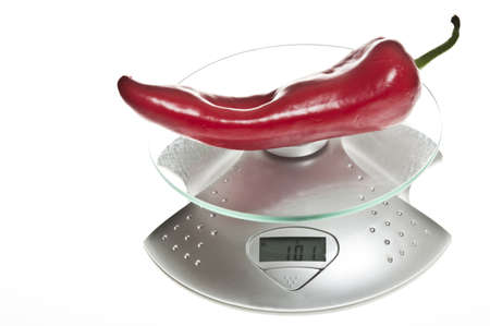 Red pepper isolated on food scaleの写真素材