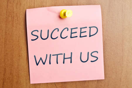 Succeed with us words  post it on wooden wallの写真素材