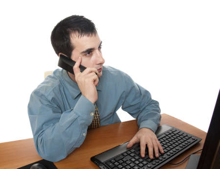 Isolated worker at office desk talking on phoneの写真素材