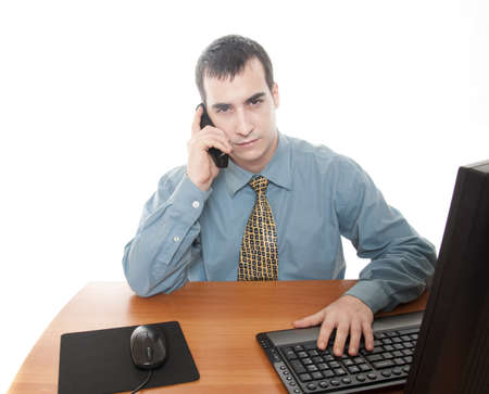 Isolated worker at office desk talking on phoneの写真素材